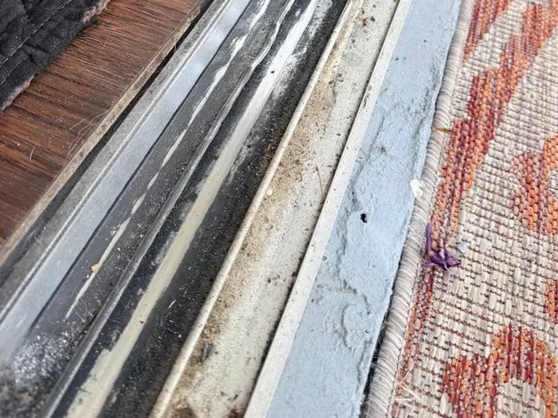 Worn and bent sliding door track before repair
